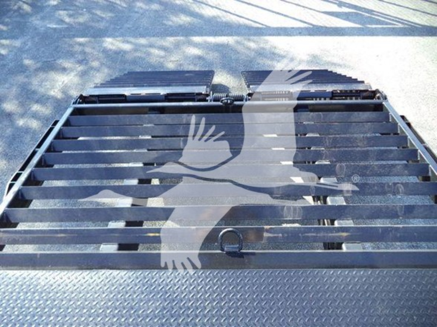 Truck bed area showing metal platform with slatted surface and diamond plate edging.