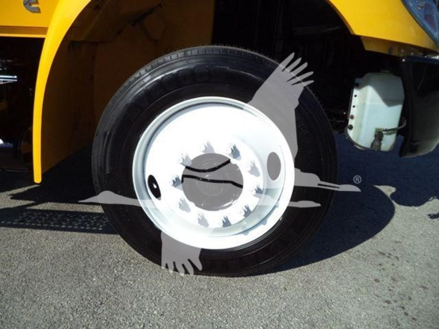 Truck wheel and front fender of a 2019 International 4300 Auto Carrier showing front tire and wheel.