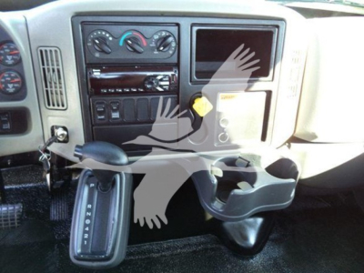 Dashboard and gear selector area of a 2019 International 4300 auto carrier, showing steering column, center console, climate controls, radio, cup holder, and gear shift with PRNDL indicators.