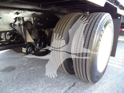 Truck rear axle and dual tires of a 2019 International 4300 auto carrier, showing tire tread and undercarriage components.