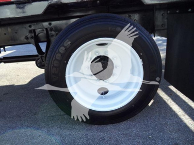 Trailer wheel and tire assembly on a 2019 International 4300 low-profile truck chassis showing a white steel wheel and black tire.