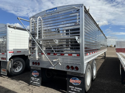 Stoughton air ride grain trailer rear view showing metal side rails and bumper with company label; dual rear axles and tailgate in open position.