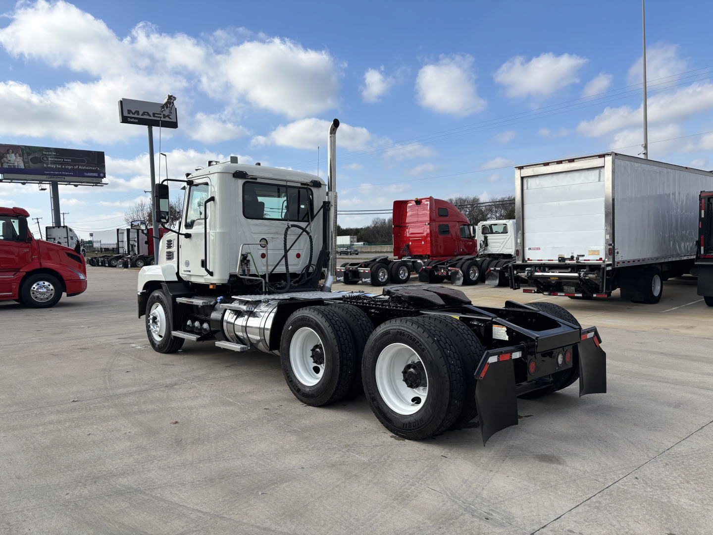 Truck chassis with cab showing 2020 Mack AN64T, semi truck tractor, dual rear axles, white cab, black frame, fifth wheel missing, daycab configuration.