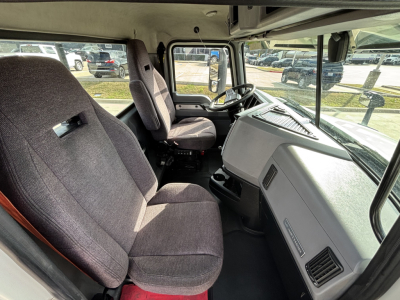 Truck cab interior view of a 2020 Mack AN64T showing front seats, steering wheel, dashboard, and windshield.