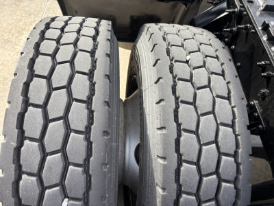Truck axle area showing dual rear tires with tread patterns and sidewall details.