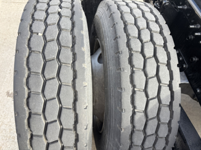 Conventional daycab truck dual rear tires with hexagonal tread pattern and visible tread wear.