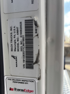 Mack AN64T truck door sticker with VIN 1M1AN3GYXLM018831 and barcode, TransEdge inspection label, and MACK TRUCKS INC branding.