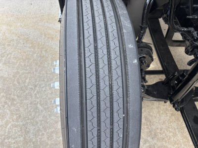 Truck wheel and tire close-up on Mack AN64T conventional daycab showing tread and lug nuts.