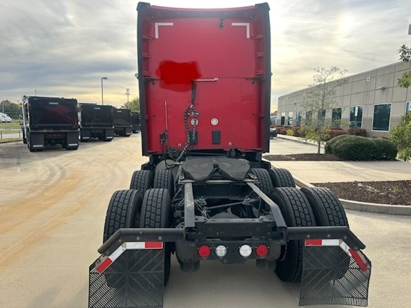Kenworth T680 rear view showing fifth wheel area and dual rear axles with mud flaps and bumper lights.