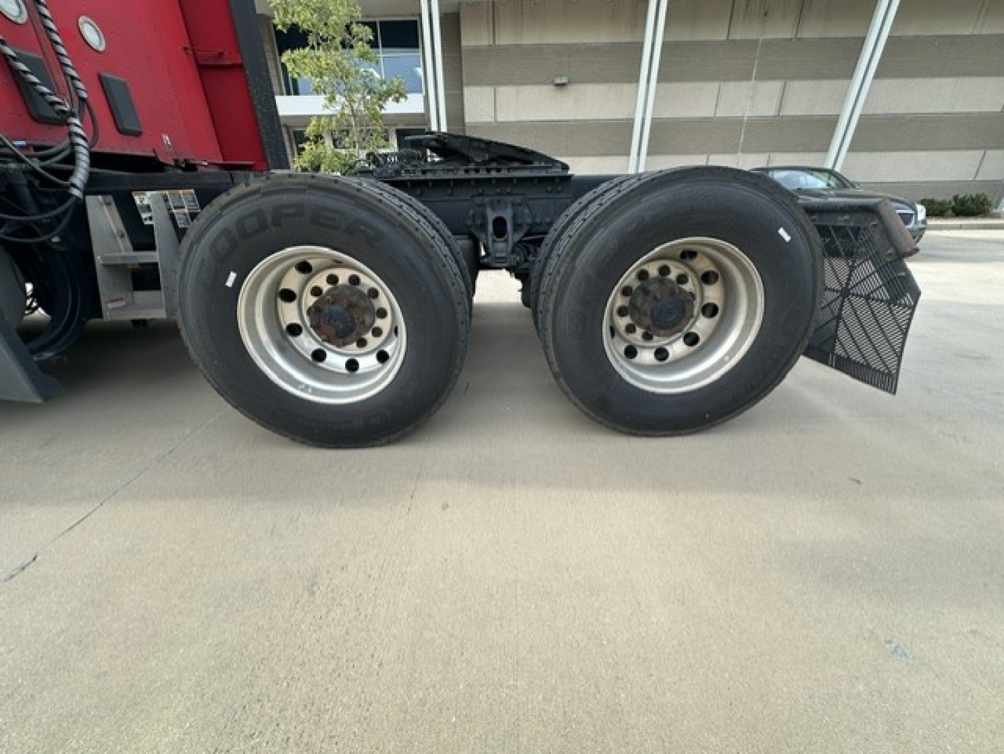 Twin rear wheels of a Kenworth T680 tractor showing steel rims and Goodyear tires.
