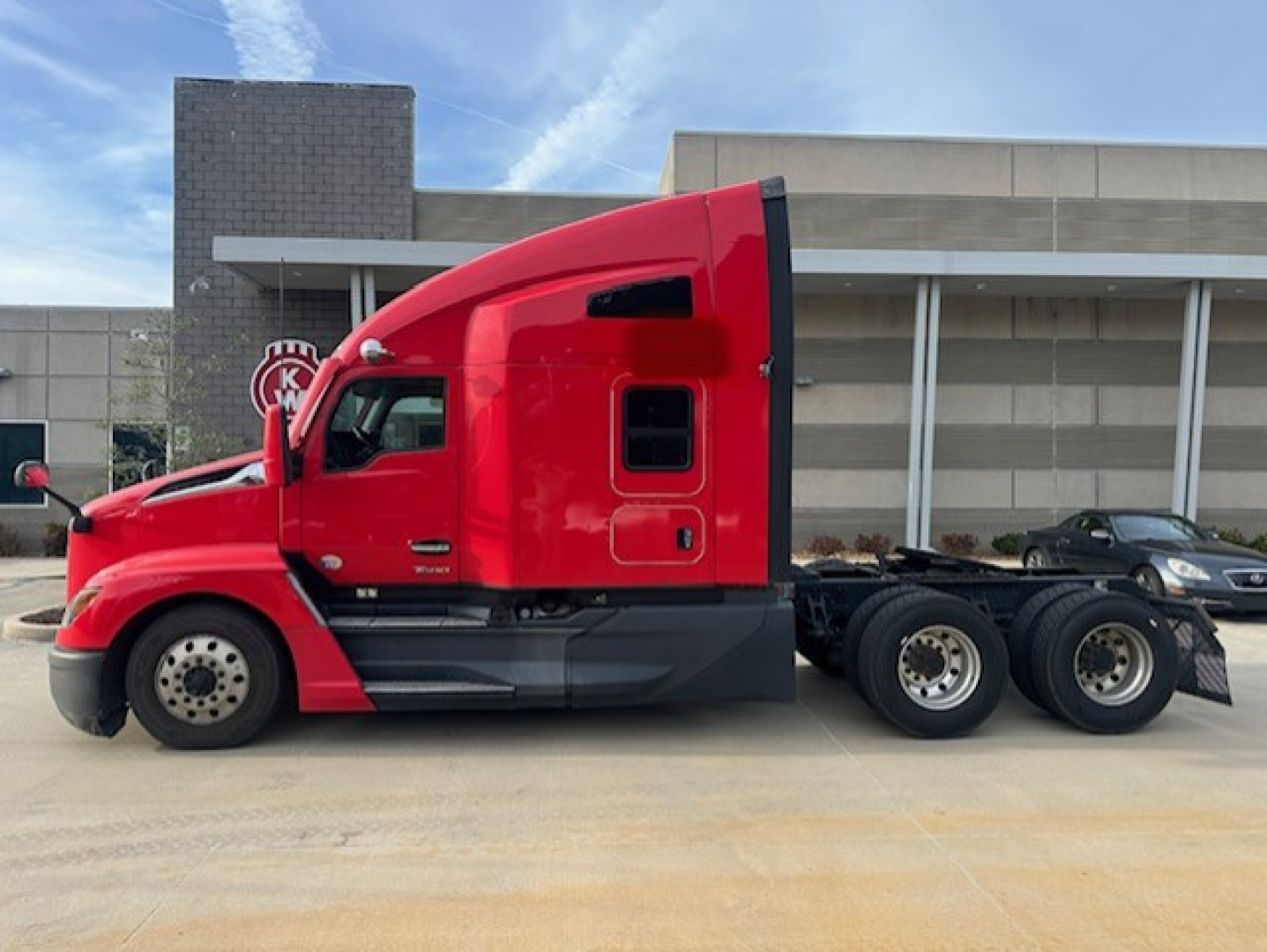 Kenworth T680 sleeper cab tractor truck side profile with bright red paint and dual rear axles.