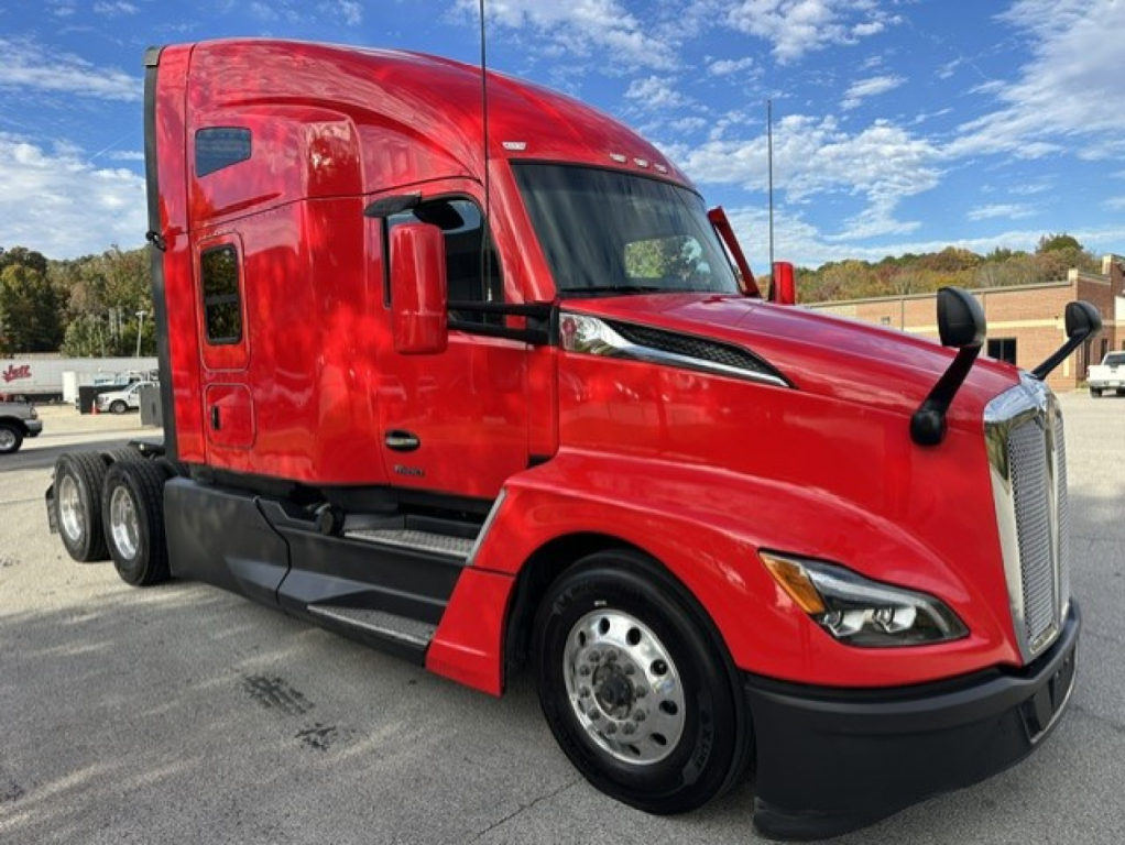 Kenworth T680 conventional sleeper truck in red, side view showing cab, front grille, wheel, and side mirror.
