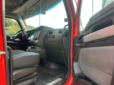 Kenworth T680 truck cab interior view showing steering wheel, dashboard, and driver seat from doorway.
