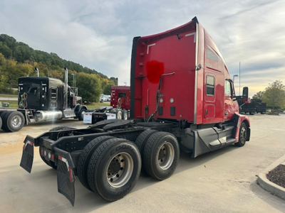 Kenworth T680 tractor rear view showing dual rear axles and red sleeper cab, no text legible on visible surfaces.