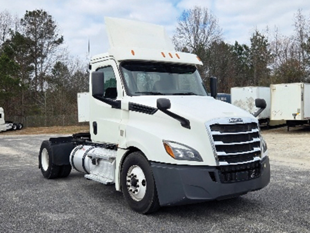 Truck cab of a white 2020 Freightliner Cascadia126 conventional daycab, showing front grille, headlights, and side mirrors.