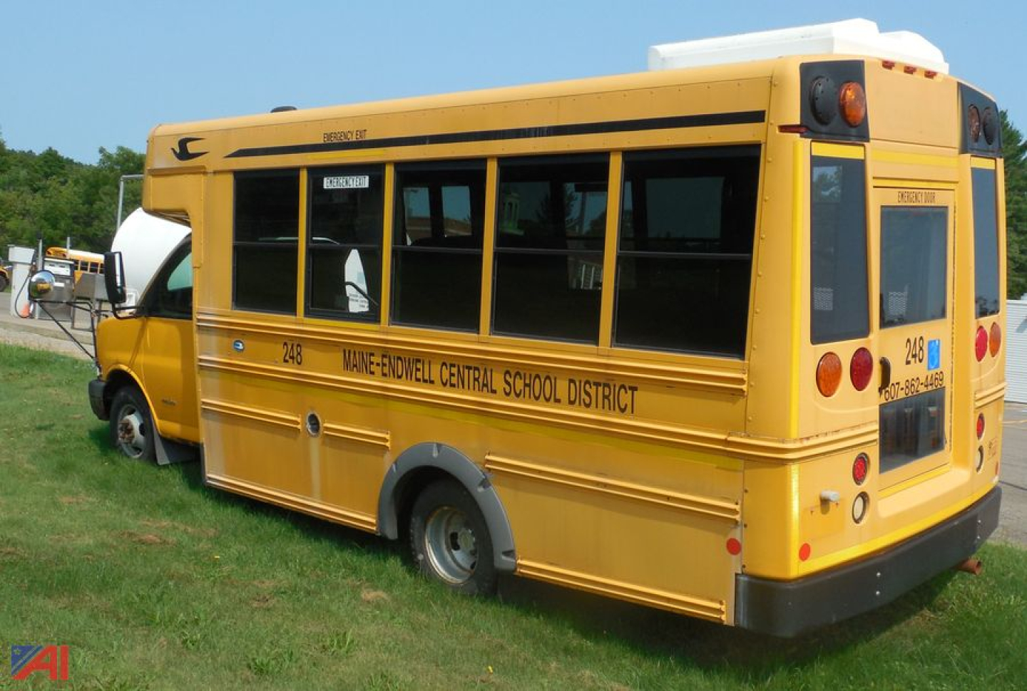 Yellow 2012 Chevrolet Express Micro Bird school bus with wheelchair lift, side windows, rear view showing school district text.