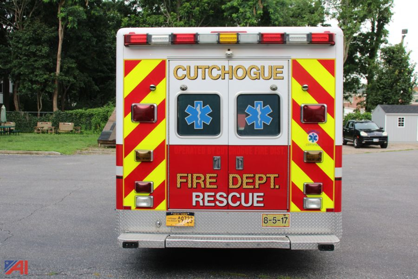 Rear view of a red and white ambulance with chevron pattern, emergency symbols, and text reading FREE and RESCUE. Visible text includes CUTCH0GUE? CUTHOGUE? above the rear doors, FIRE DEPT. RESCUE, and ambulance lighting.