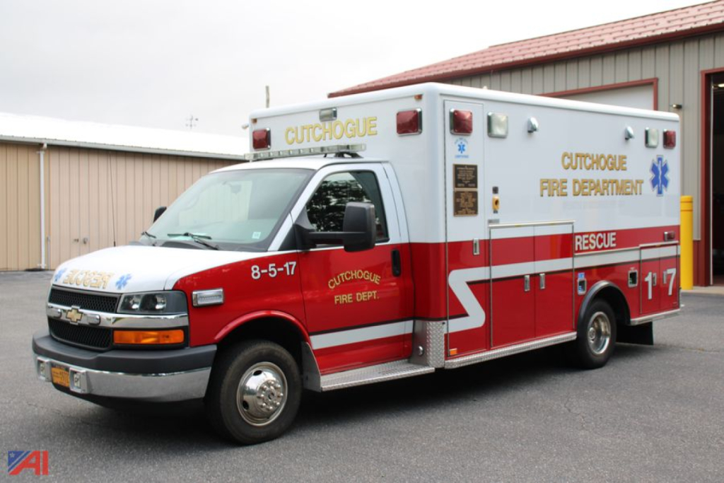 Ambulance exterior showing Cutchogue Fire Department label and red/white livery, ambulance box with rear rescue door, front cab Chevrolet engine.