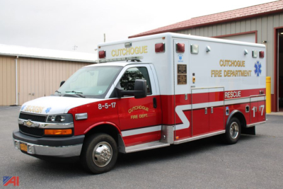 Ambulance exterior showing Cutchogue Fire Department label and red/white livery, ambulance box with rear rescue door, front cab Chevrolet engine.