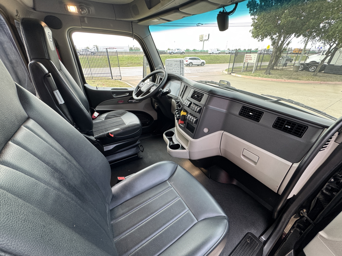 Interior of a 2022 Peterbilt 579 cab showing steering wheel, dashboard, and seats.
