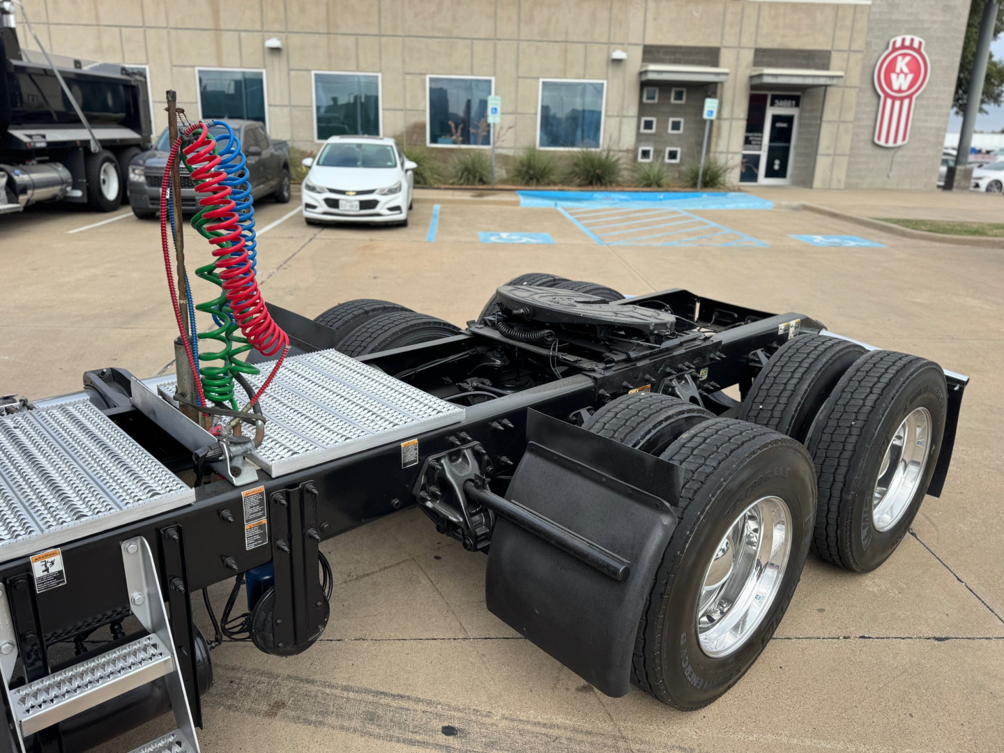 Peterbilt 579 chassis with dual rear axles and air hoses showing cabless tractor frame in a parking lot.