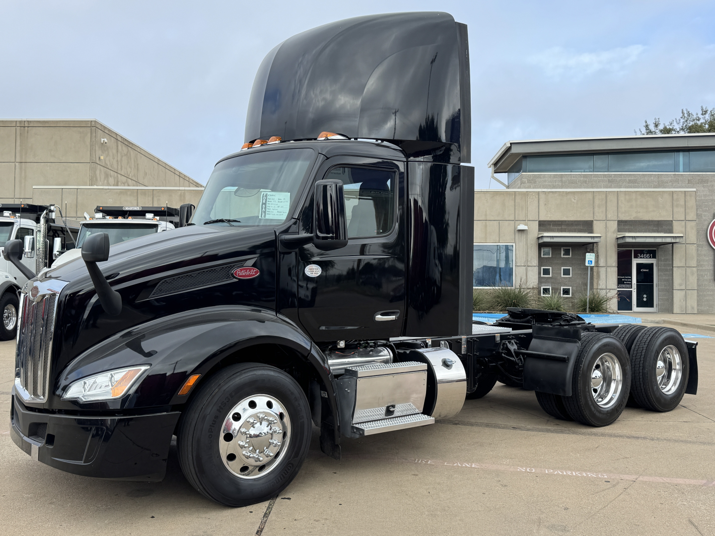 Peterbilt 579 conventional daycab tractor in glossy black exterior. Front cab with large hood and sleeper height, dual rear axles, chrome fuel tanks, polished aluminum wheels, and raised black aerodynamic sleeper fairing.