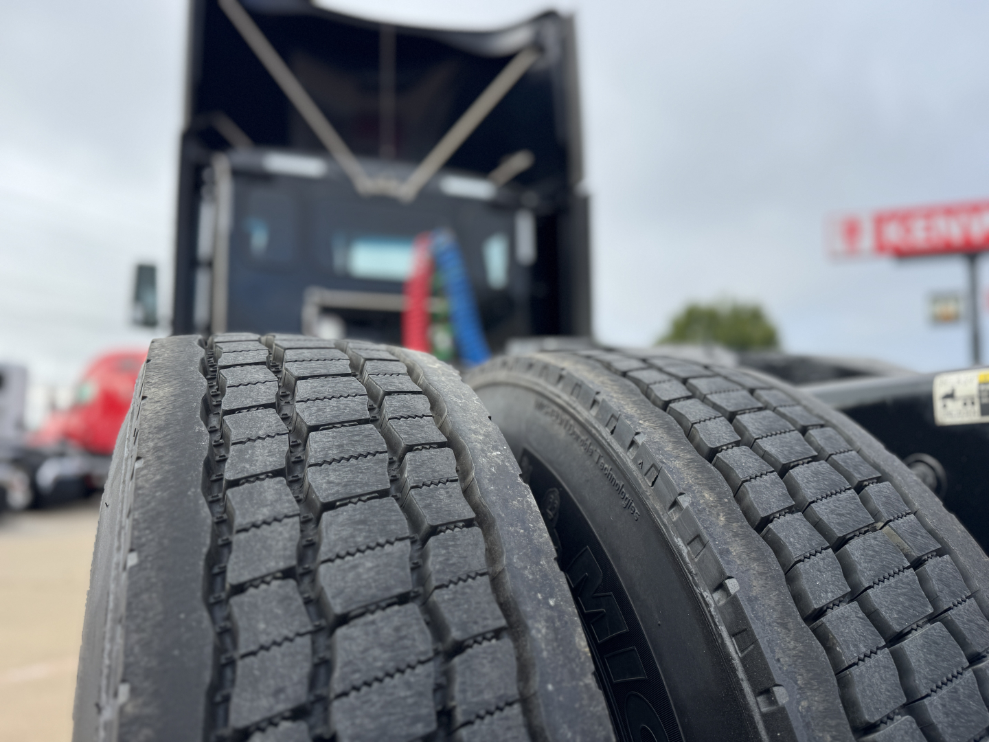 Dual rear truck tires in foreground with cab and trailer in background on a Peterbilt 579 conventional daycab.