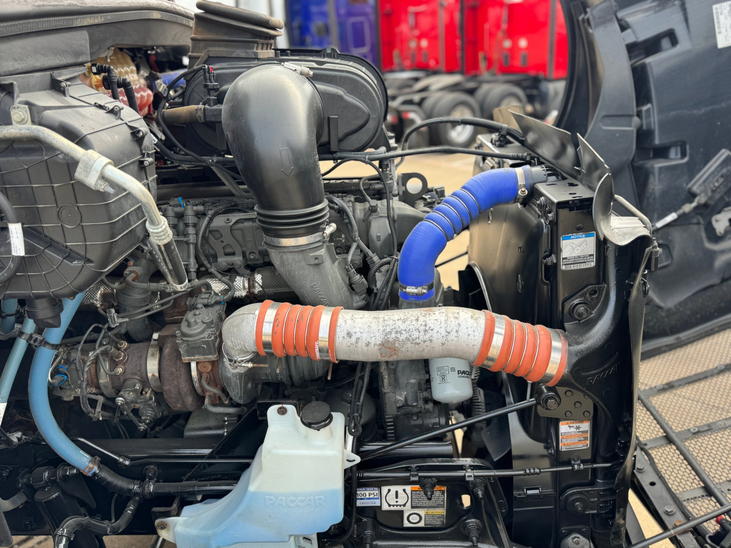 Peterbilt 579 engine bay showing intercooler piping, blue silicone hose, and radiator area visible under hood