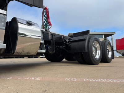 Peterbilt 579 conventional daycab chassis and dual rear axles showing rear wheels and chrome fuel tank.