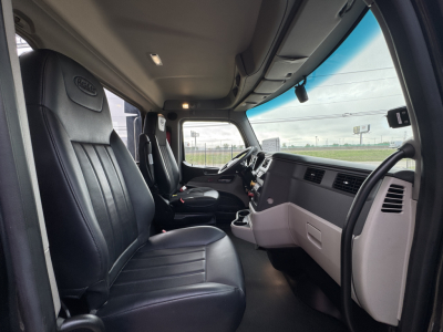 Peterbilt 579 interior cab view showing driver and passenger seats, dashboard, steering wheel, and center console.