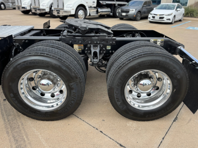 Peterbilt 579 rear axle with dual tires and chrome wheels on a daycab chassis showing the fifth wheel and suspension components.