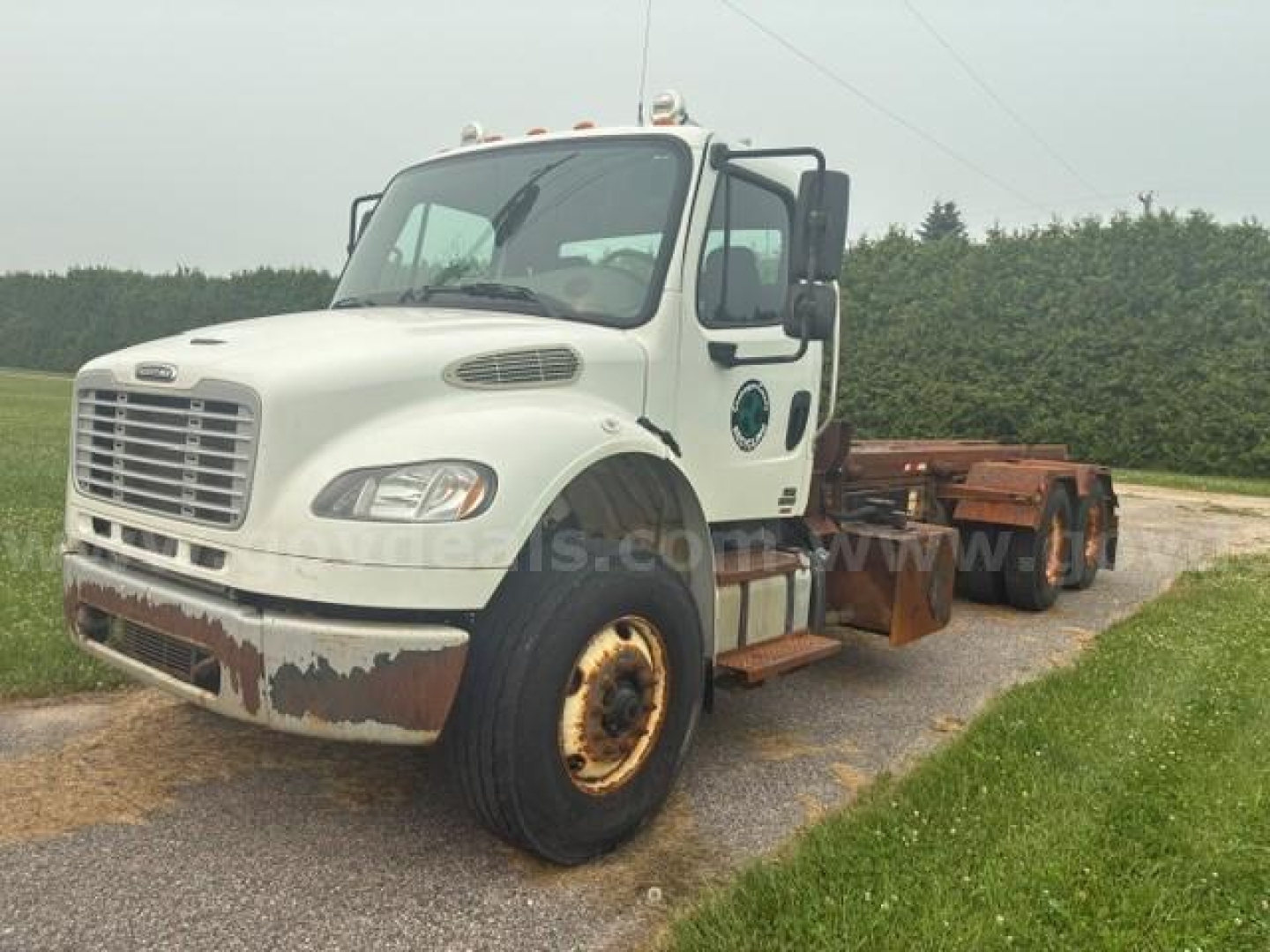 Freightliner M2 106 cab and chassis truck showing front and left side with rust on bumper and wheel hub.