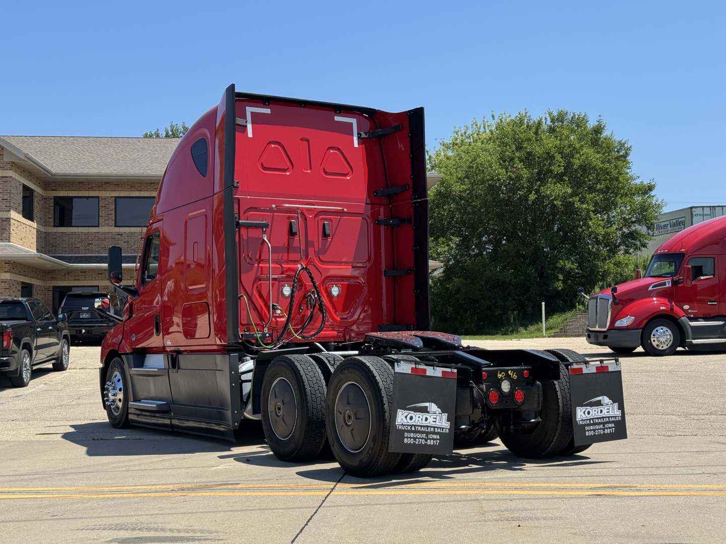 Freightliner Cascadia 126 truck rear view showing sleeper cab, red paint, dual rear axles, and mud flaps with Kordell name plate.
