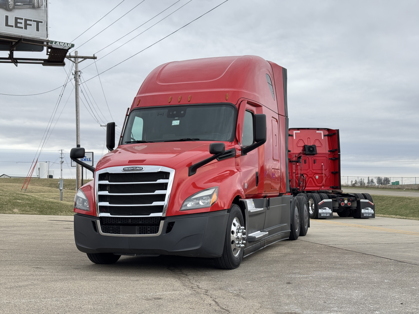 Freightliner Cascadia 126 sleeper cab tractor in red, front-left view, showing chrome grille, headlights, and side mirrors.