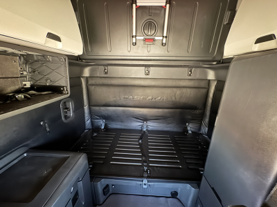 Freightliner Cascadia 126 sleeper cab cargo area showing rear cargo deck and wall panels with straps and storage compartments.