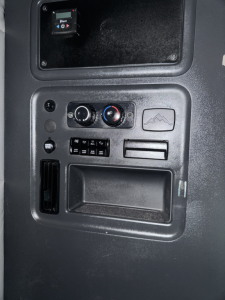 Truck cab interior panel showing HVAC controls and storage pocket; no legible model text visible