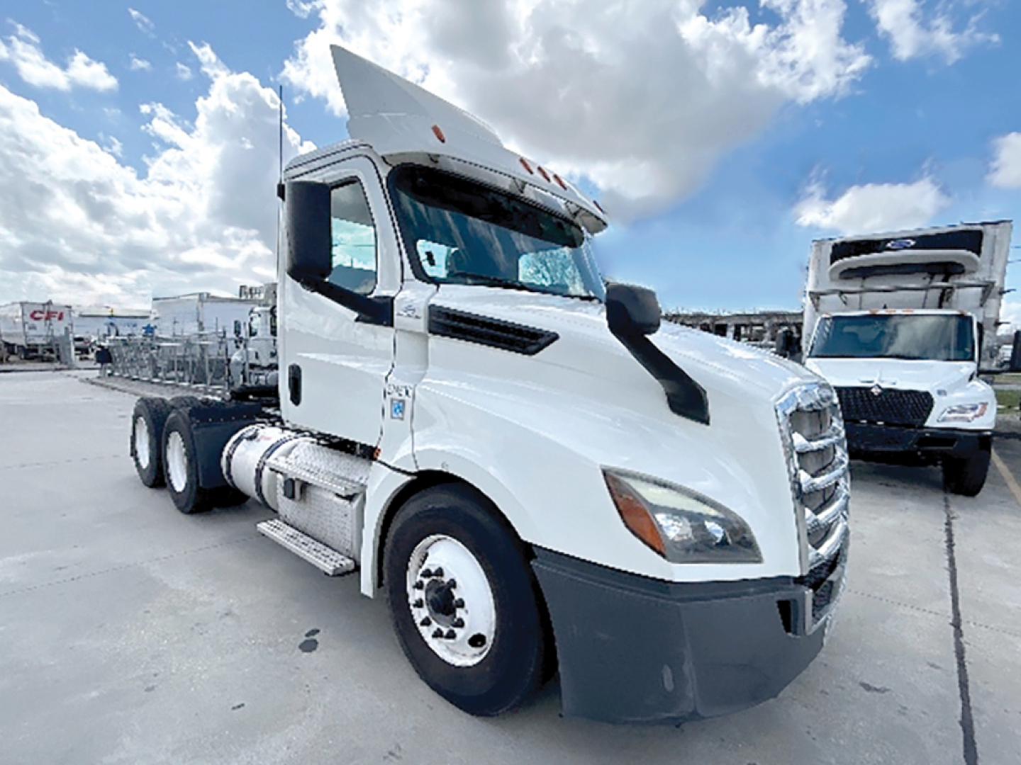 Truck showroom image of a white 2019 Freightliner Cascadia126 conventional daycab with sleeper area, front grille, side mirrors, and dual rear axles visible.