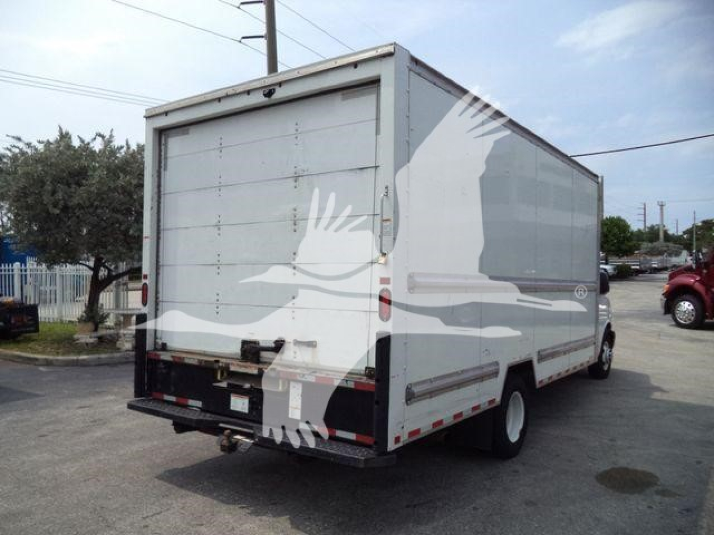 Rear and side view of a white GMC G3500 box truck with cargo area; visible text includes no legible markings on doors, tailgate, or decals.