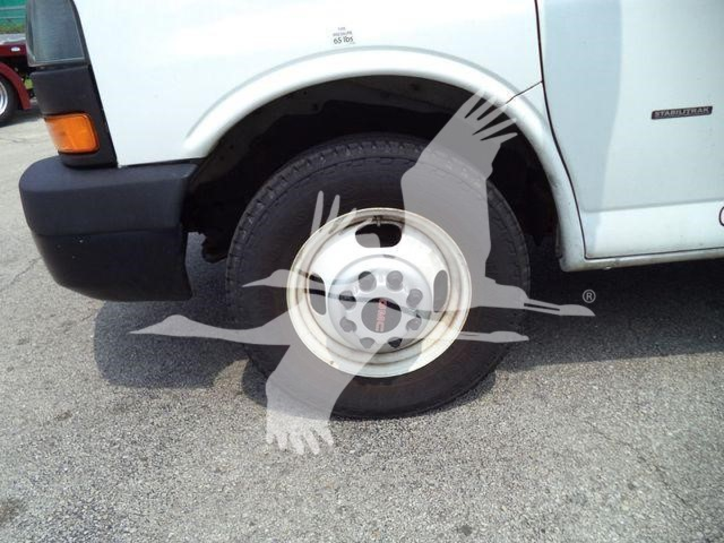 GMC G3500 front-left wheel well and tire with side panel; logo watermark overlay.