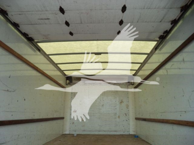 Cargo area of a GMC G3500 box truck showing interior walls, ceiling, and floor with brown rails along the sides.