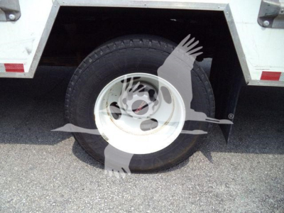 GMC G3500 wheel and tire on side view with white steel wheel and heavy-duty truck body.