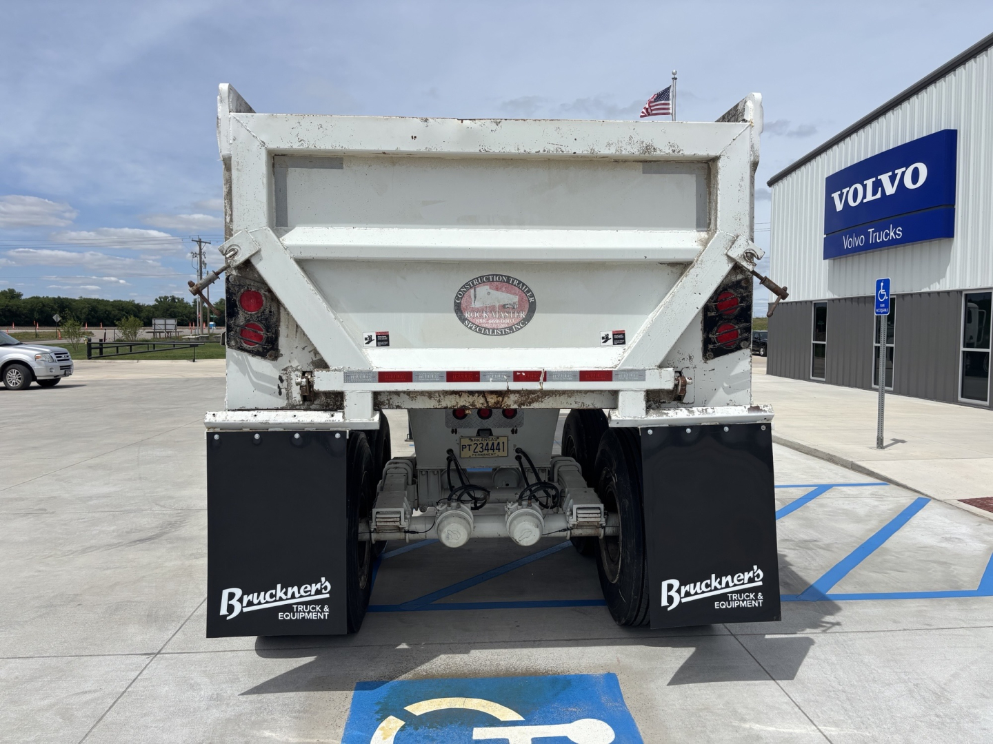 Trailer rear view showing hydraulic system and mud flaps with Buckner's decals and DOT lighting.