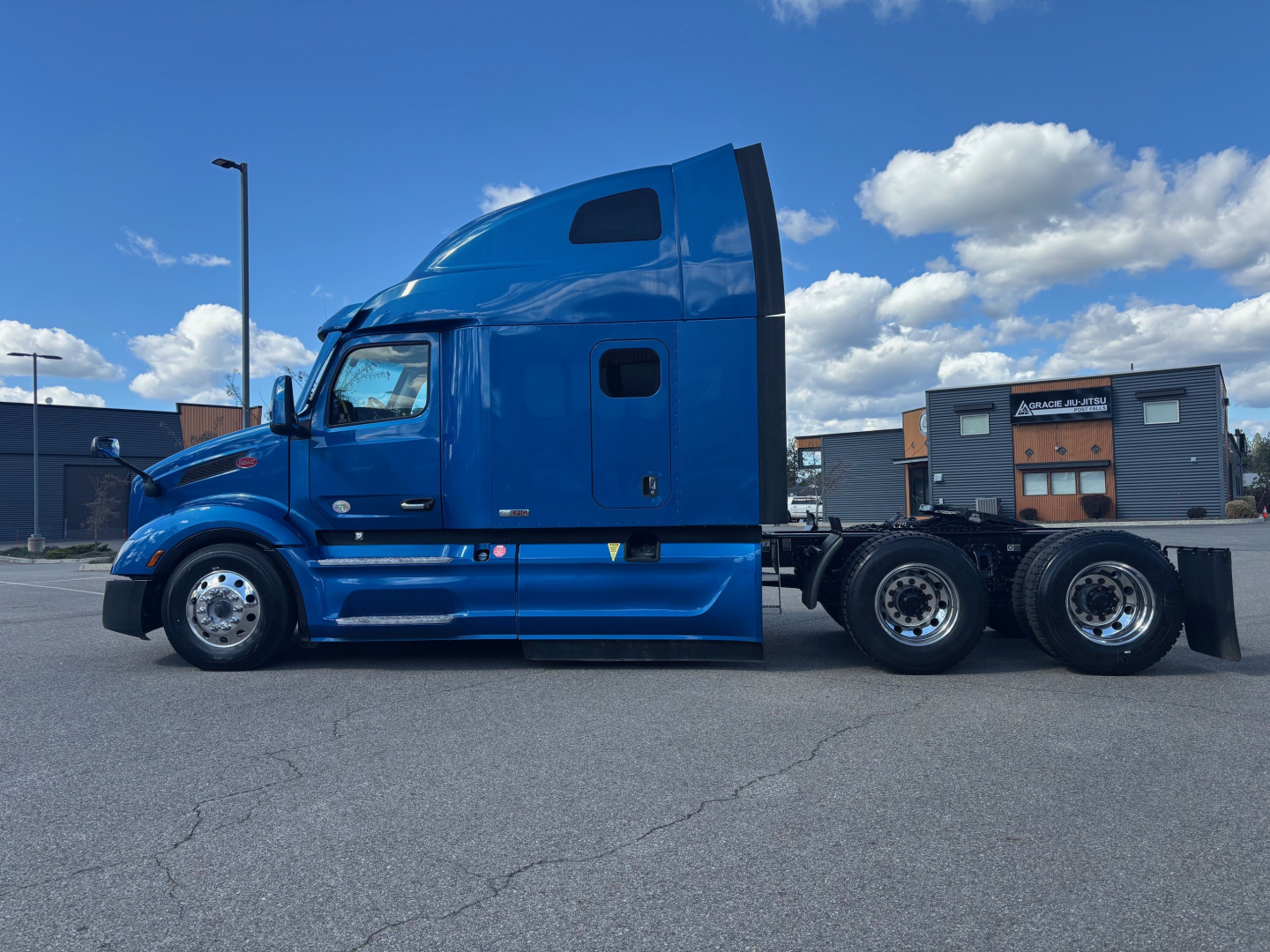 Peterbilt 579 tractor side view with blue cab and sleeper, showing truck frame and rear axles.