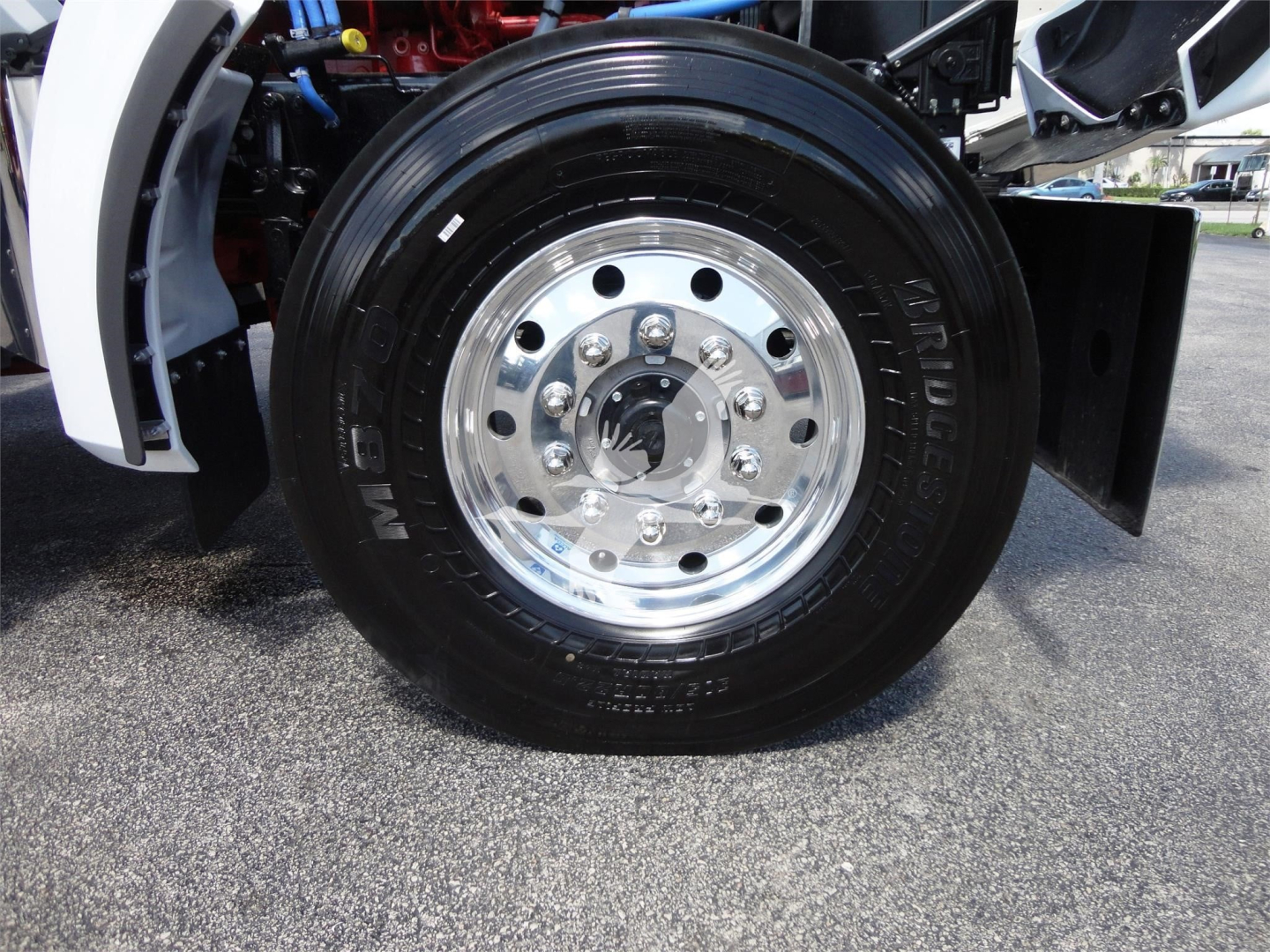 Kenworth W900 front wheel and chrome hubcap showing tire and wheel assembly.