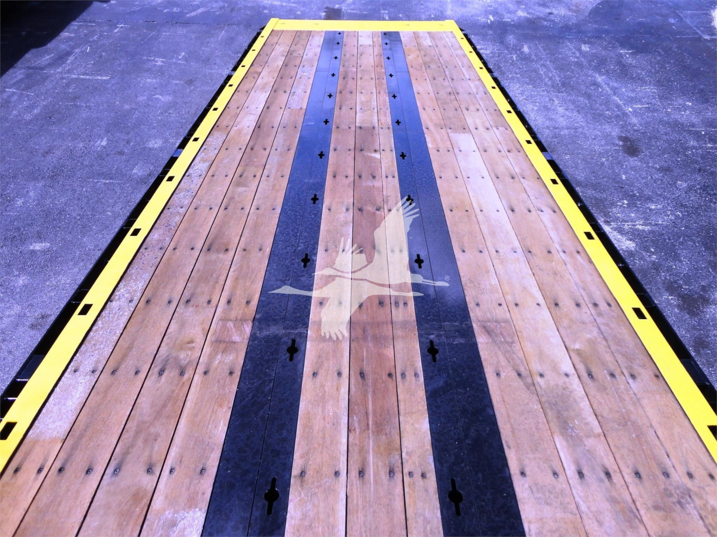 Kenworth W900 rollback truck bed with wooden planks and black center stripe.