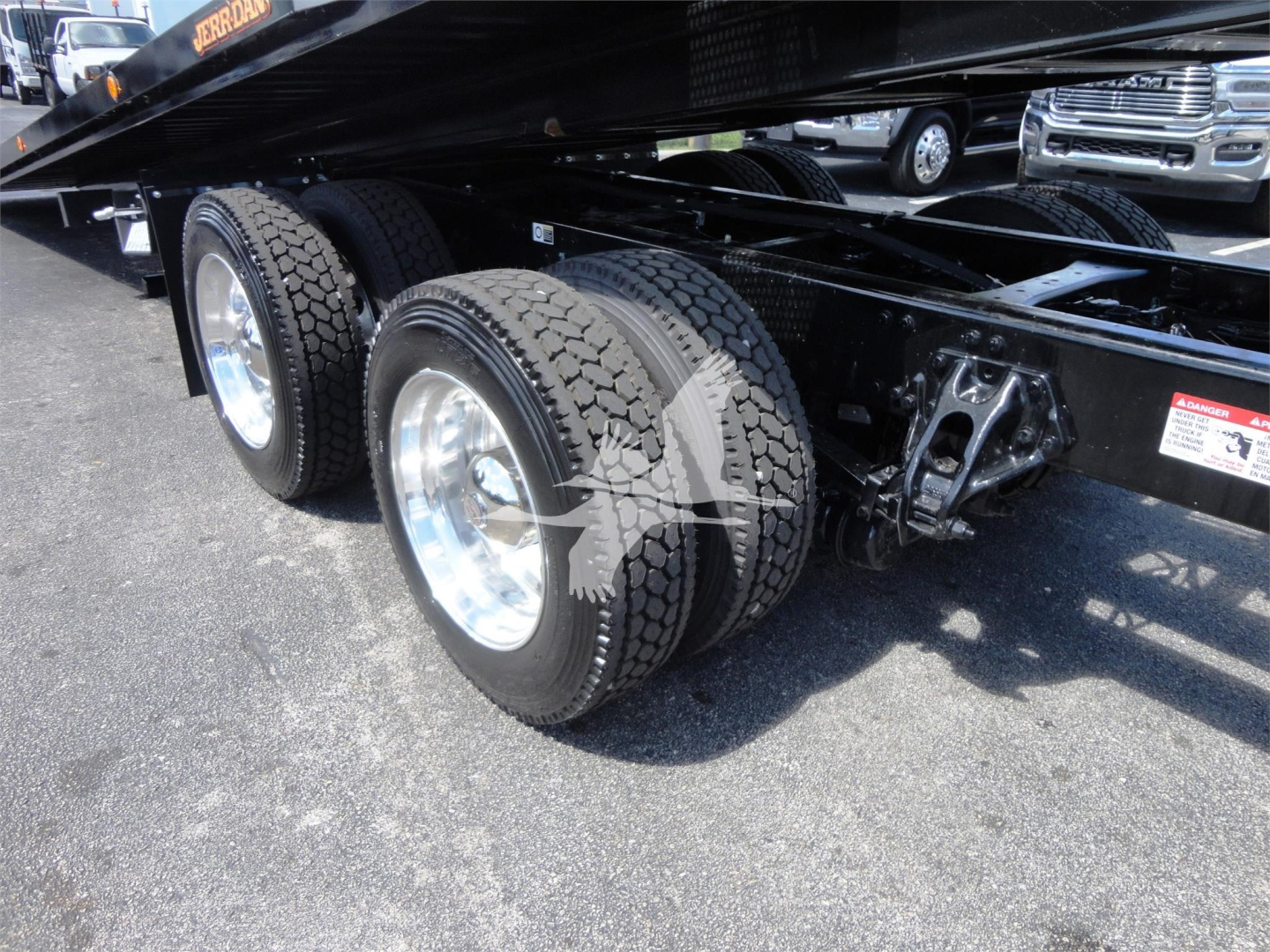 Kenworth W900 rolling chassis with tandem rear axles and dual tires. Visible wheel rims, suspension arms, and frame. No detailed text legible on the image.