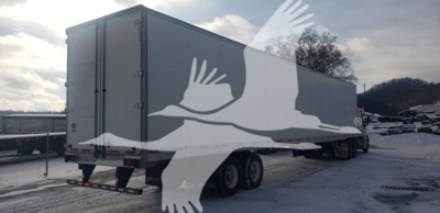 Trailer side and rear view showing a 2019 Utility 4000D-X trailer with dual rear doors, long cargo bed, snow on ground.