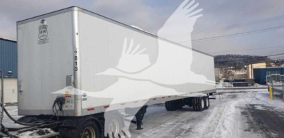 Utility trailer showing side and rear with DOT markings and hitch, 40-60 ft length underway in snow.