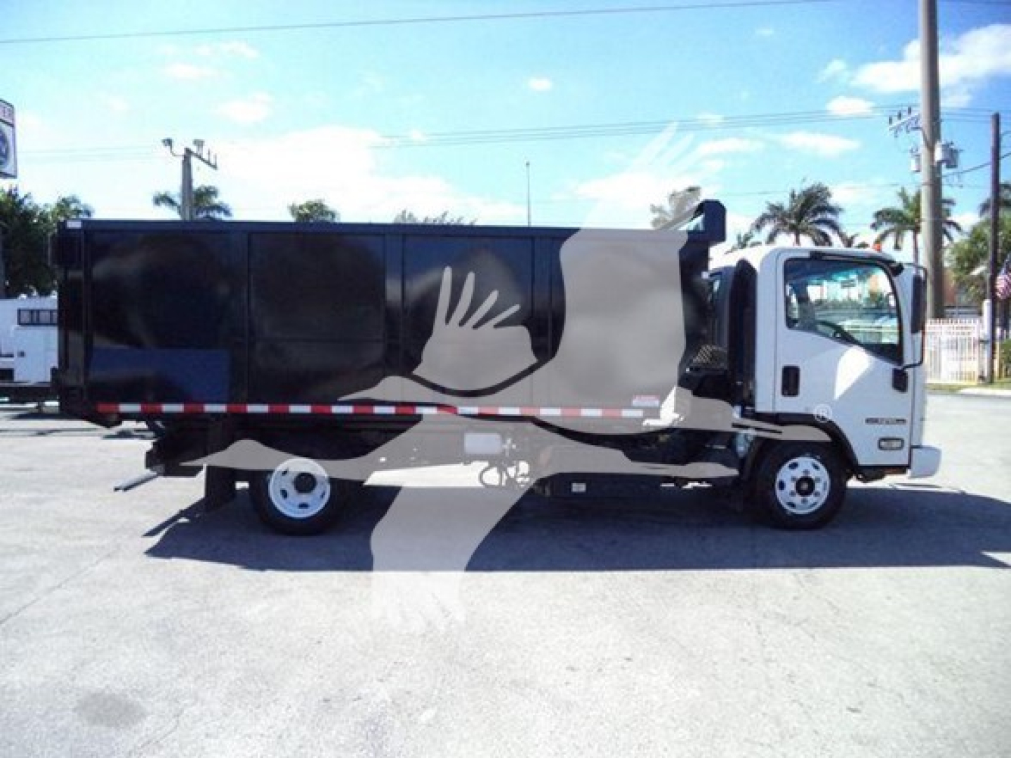 Isuzu NPR dump truck with black dump body, white cab, and lowered side profile. Side shows a graphic with a large white and gray hand-like design. No visible text.
