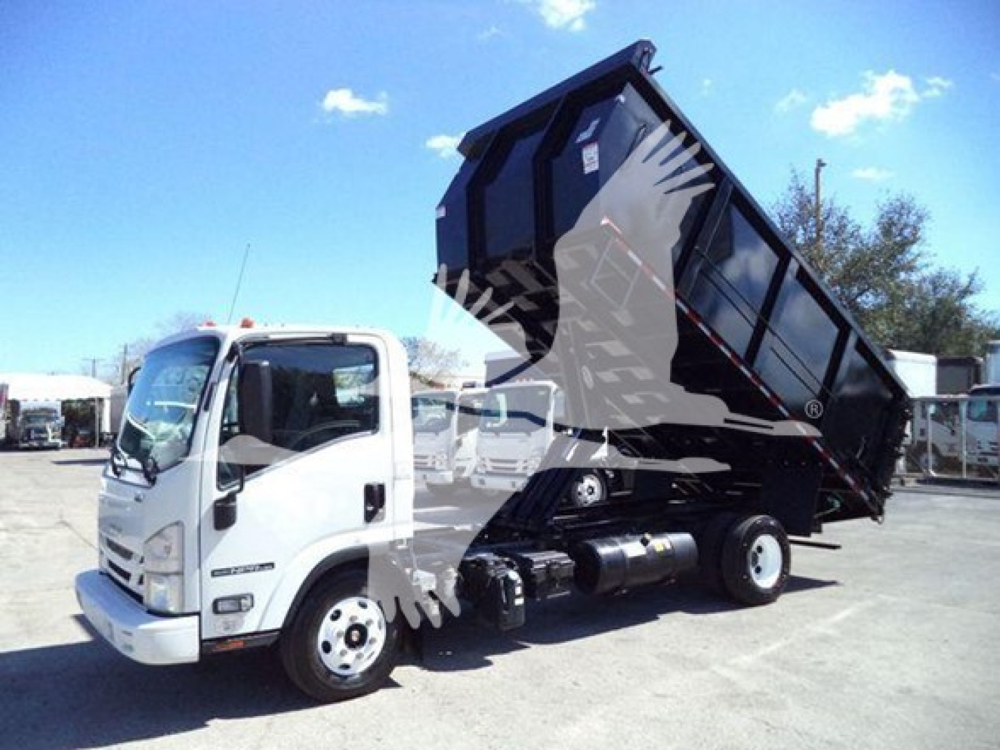 Isuzu NPR dump truck with dump bed raised showing cab and front wheel, VIN tag not readable, stock T05851.